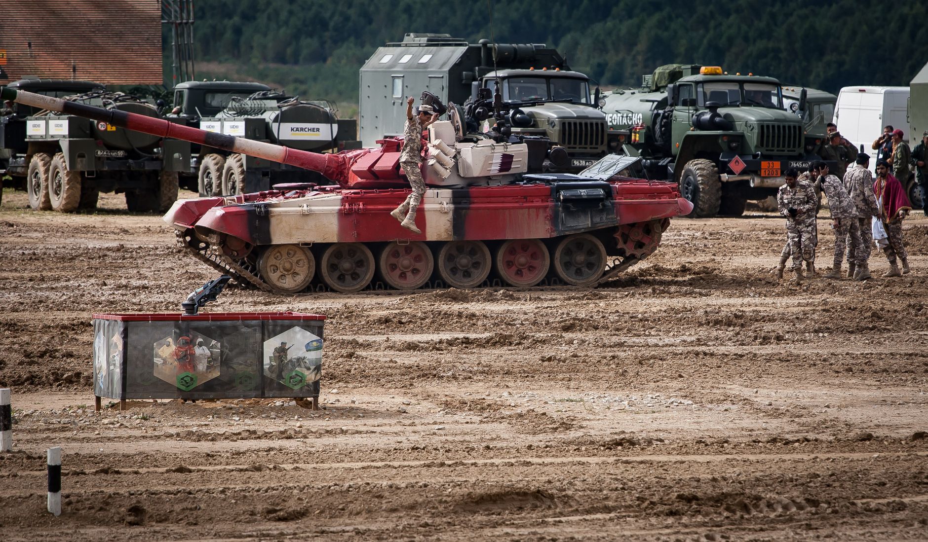 A military training exercise featuring tanks and soldiers on a field, showcasing armored vehicle operations.