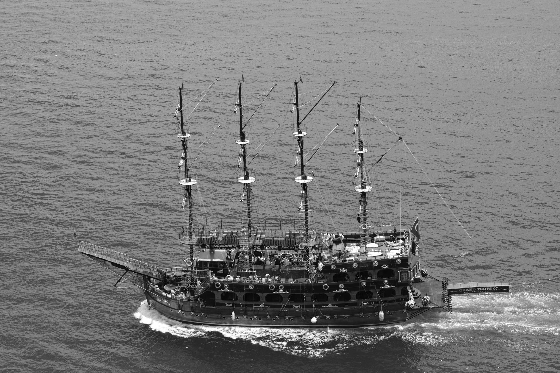 Aerial black and white photo of a pirate ship sailing the ocean, showcasing nautical adventure.