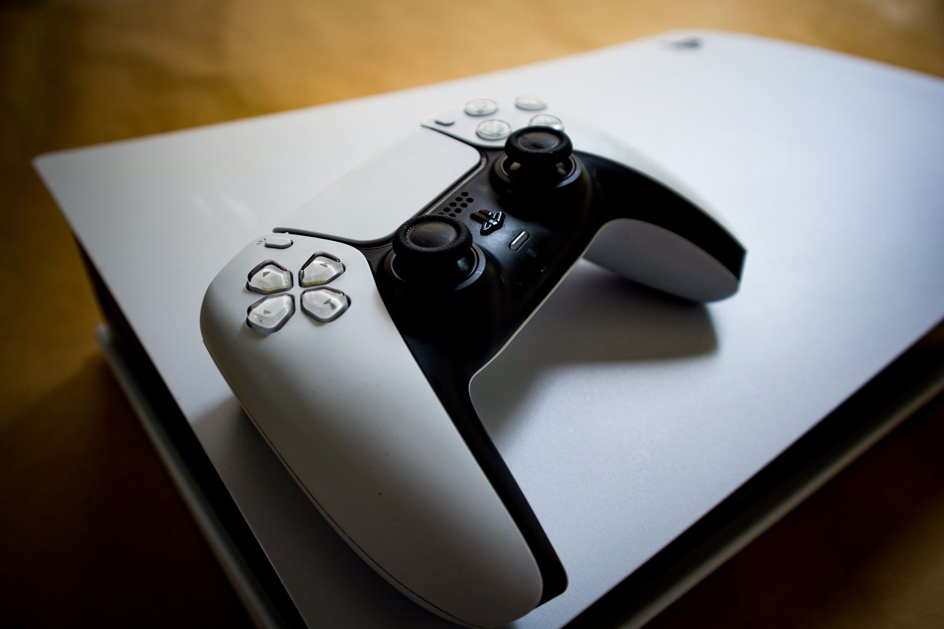 Detailed shot of a PlayStation 5 controller resting on the console, highlighting modern gaming design.