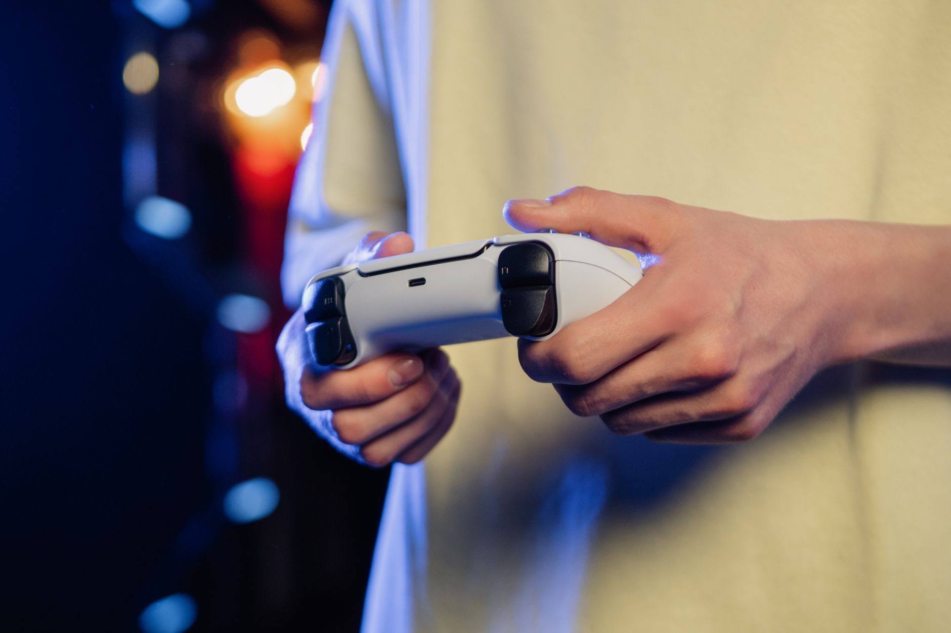 Hands gripping a game controller, displaying focus during an intense gaming session.