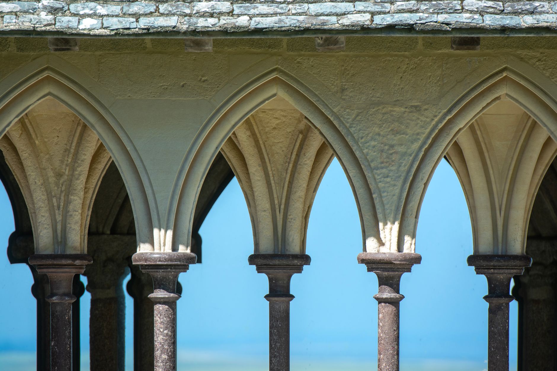 Elegant gothic arches at Mont-Saint-Michel Abbey in Normandy, France, showcasing historic architecture.