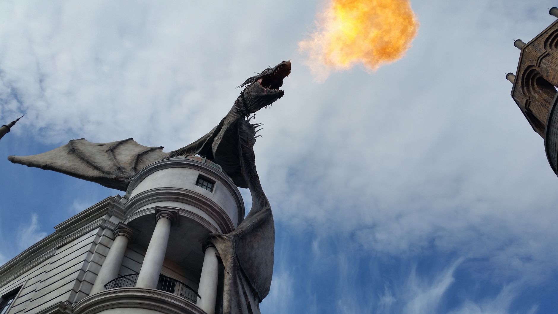 A dramatic low-angle view of a fire-breathing dragon statue against the sky in Orlando, Florida.