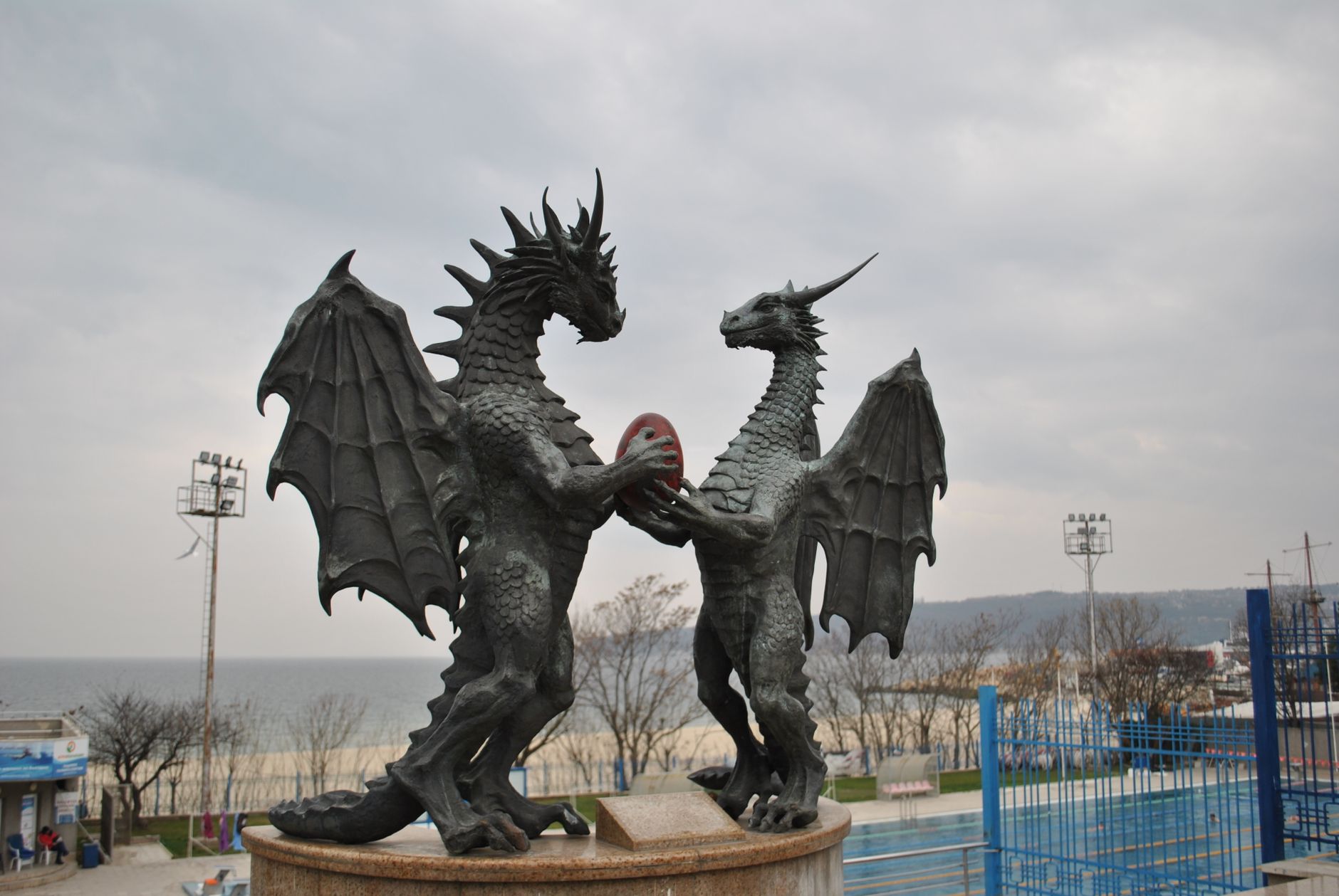 Two majestic dragon statues facing each other by the seaside.
