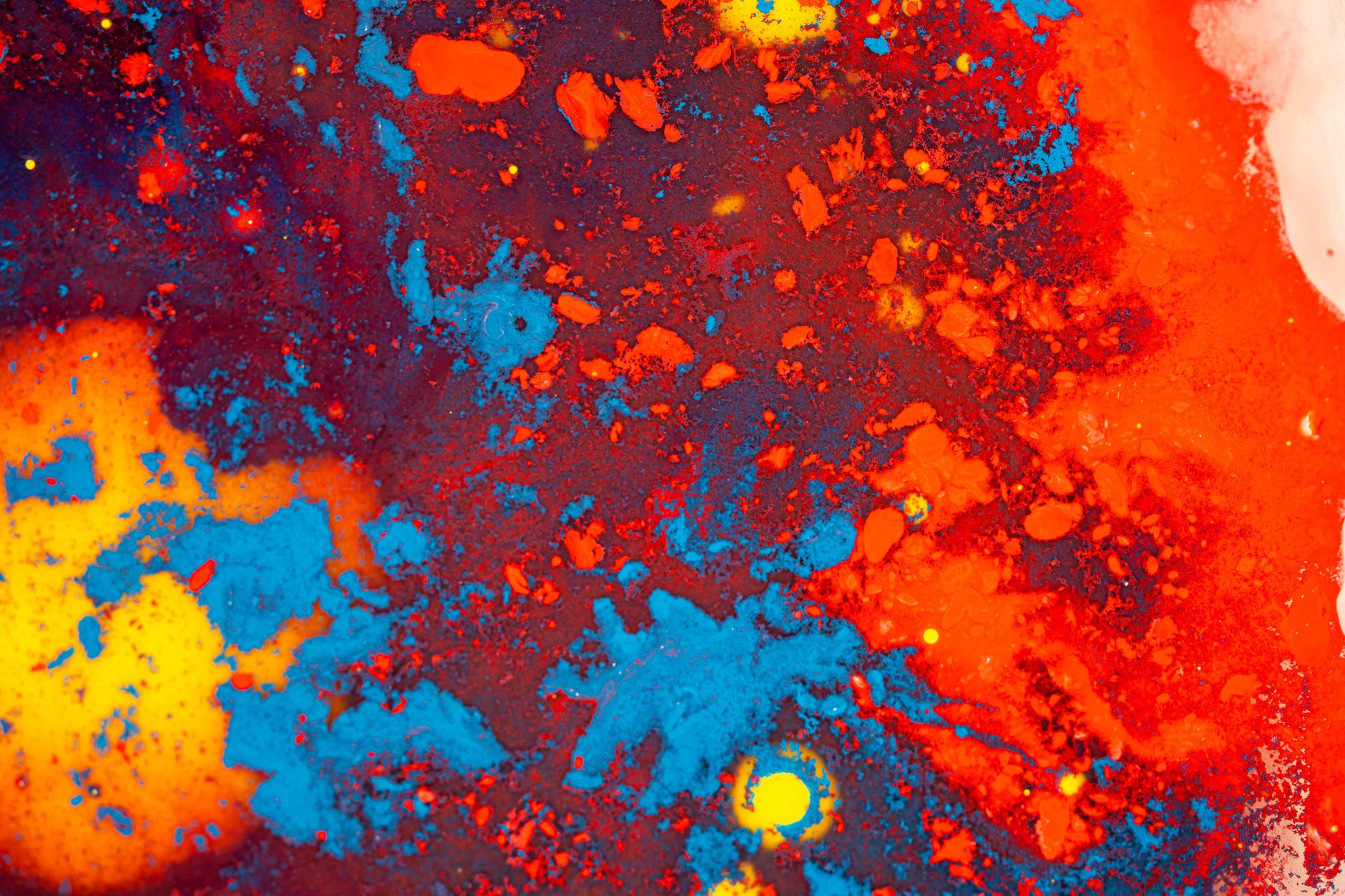 Explore a vibrant abstract texture with splashes of red, blue, and yellow paint, creating a dynamic visual experience.