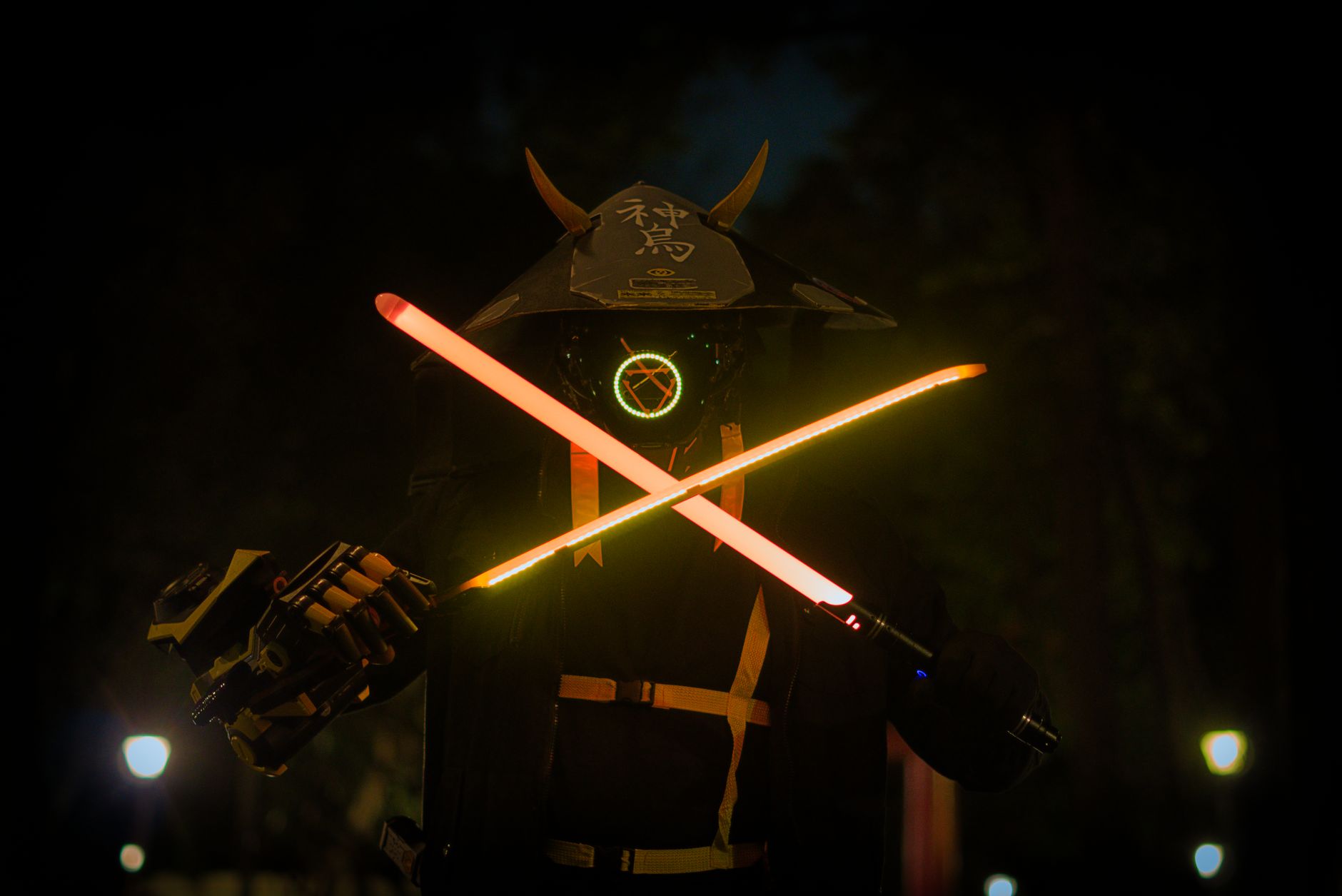 A futuristic samurai in a helmet and mask holding glowing neon swords at night.