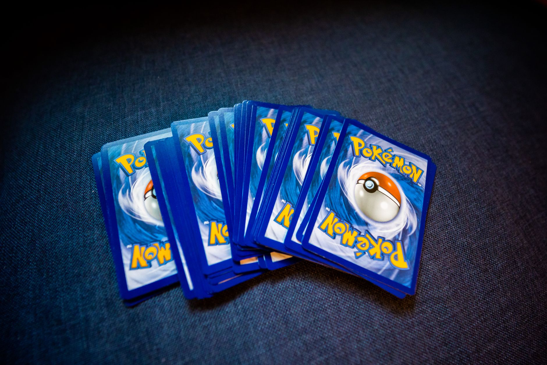 High angle of set of trading cards with images of fictional creatures placed against gray background