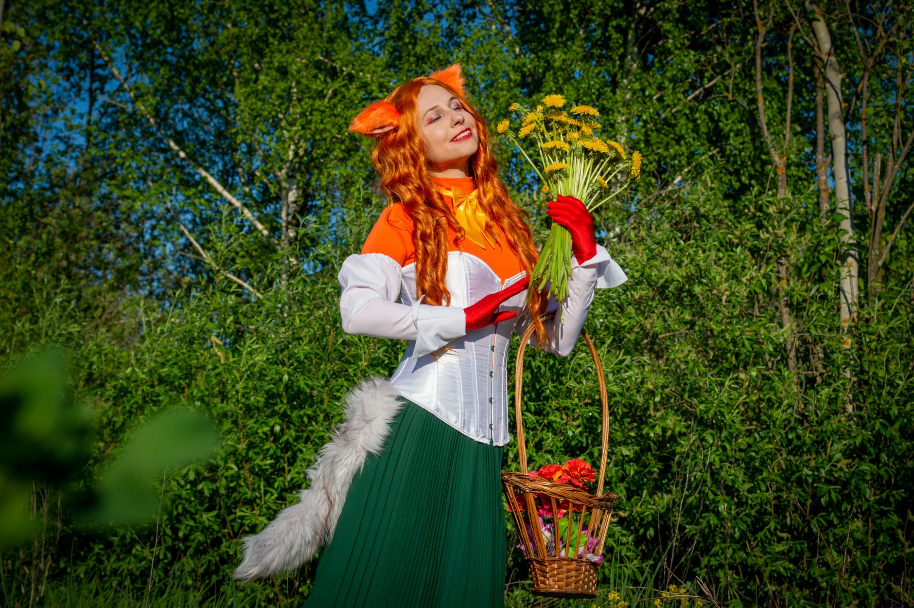 A woman in a vibrant fox costume enjoys a sunny day with dandelions.