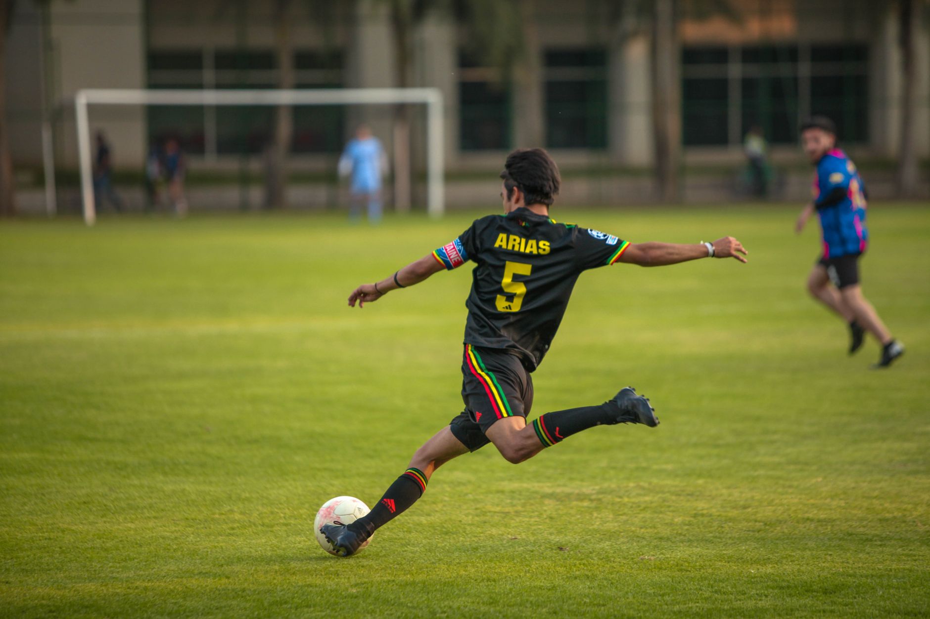 Dynamic shot of a soccer player in action during a match on a grassy field.