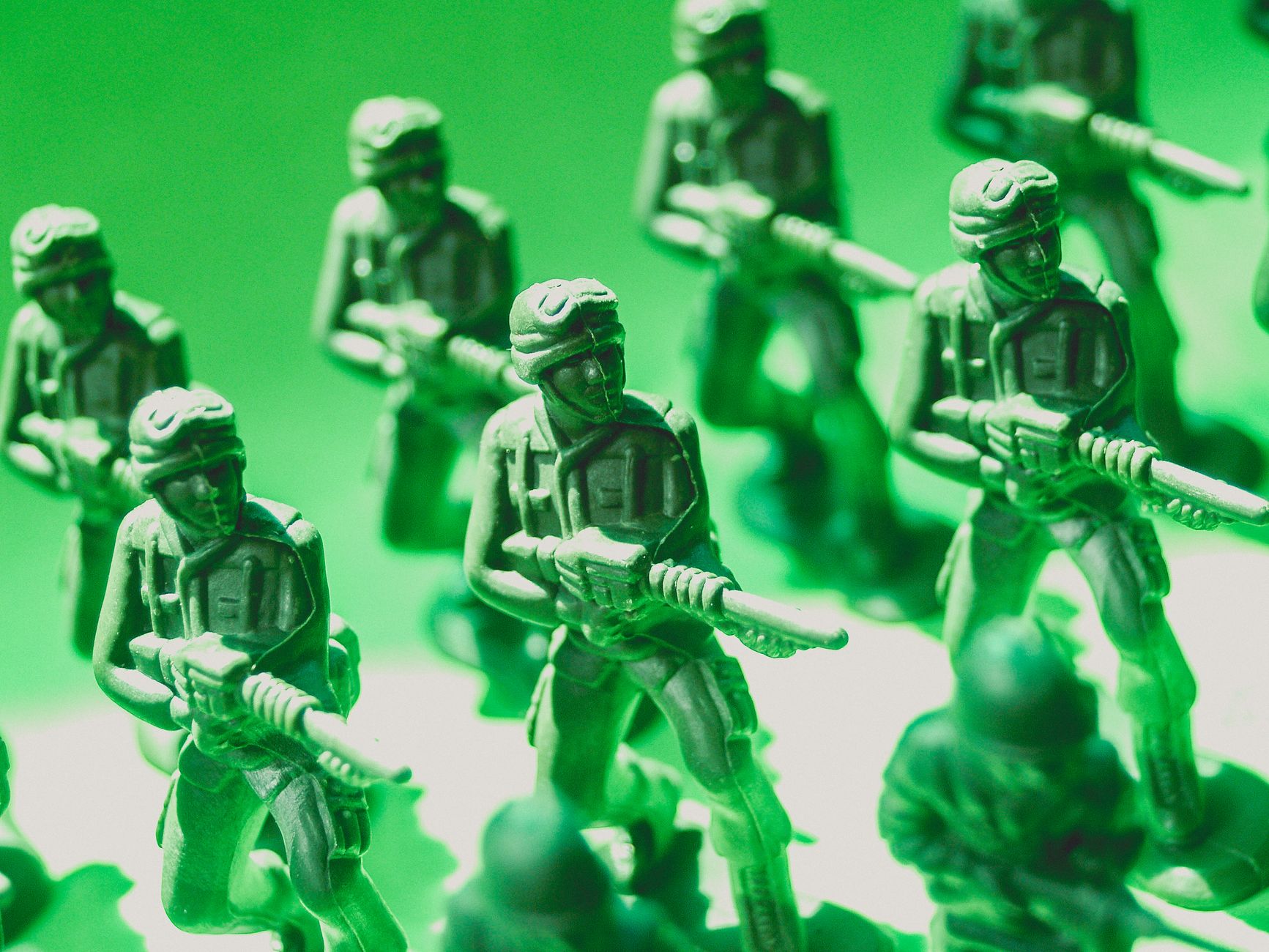 Detailed view of green plastic toy soldiers lined up in formation, symbolizing strategy and teamwork.