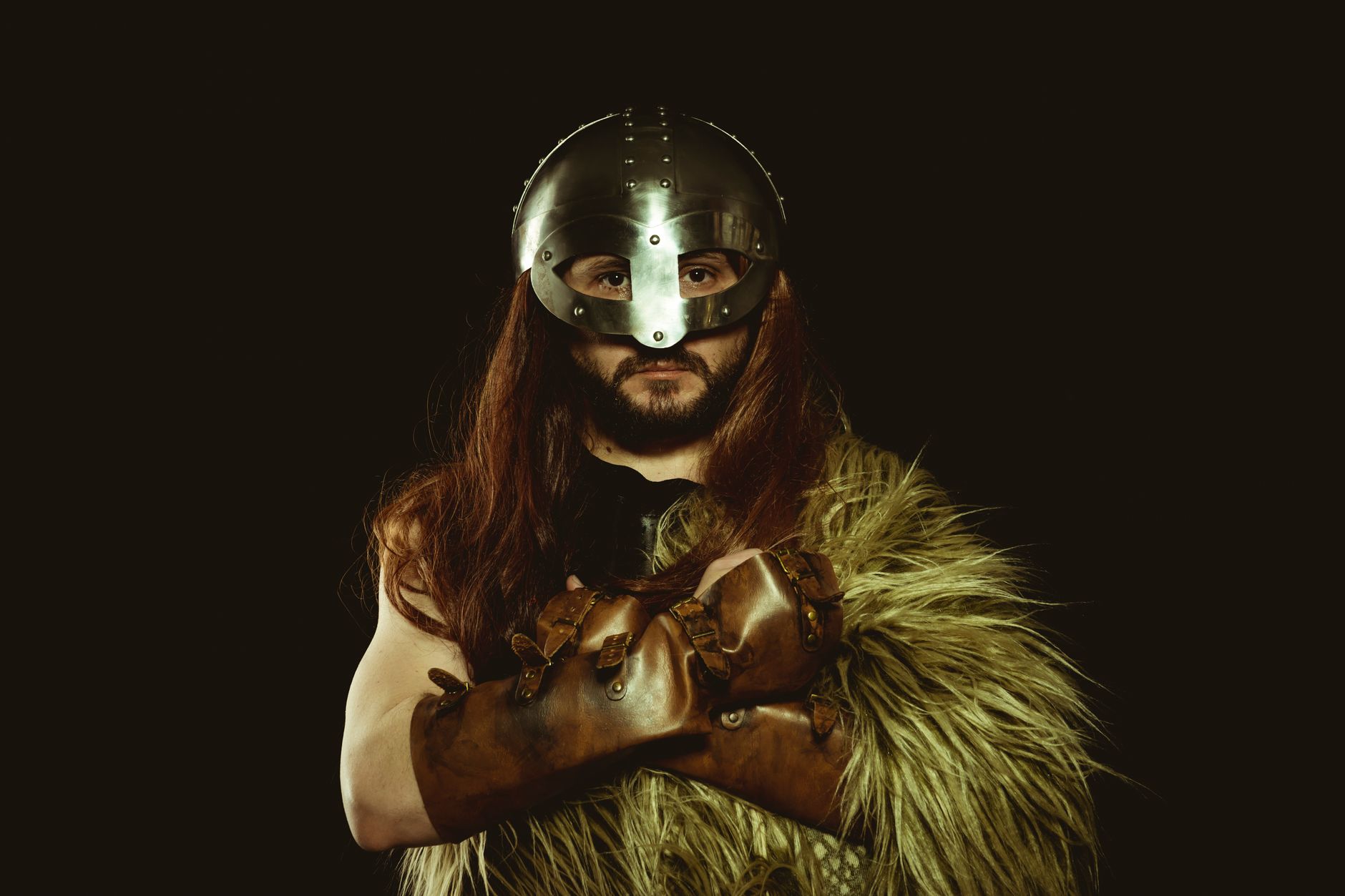 A viking warrior in armor, posing confidently with crossed arms and wearing a helmet.