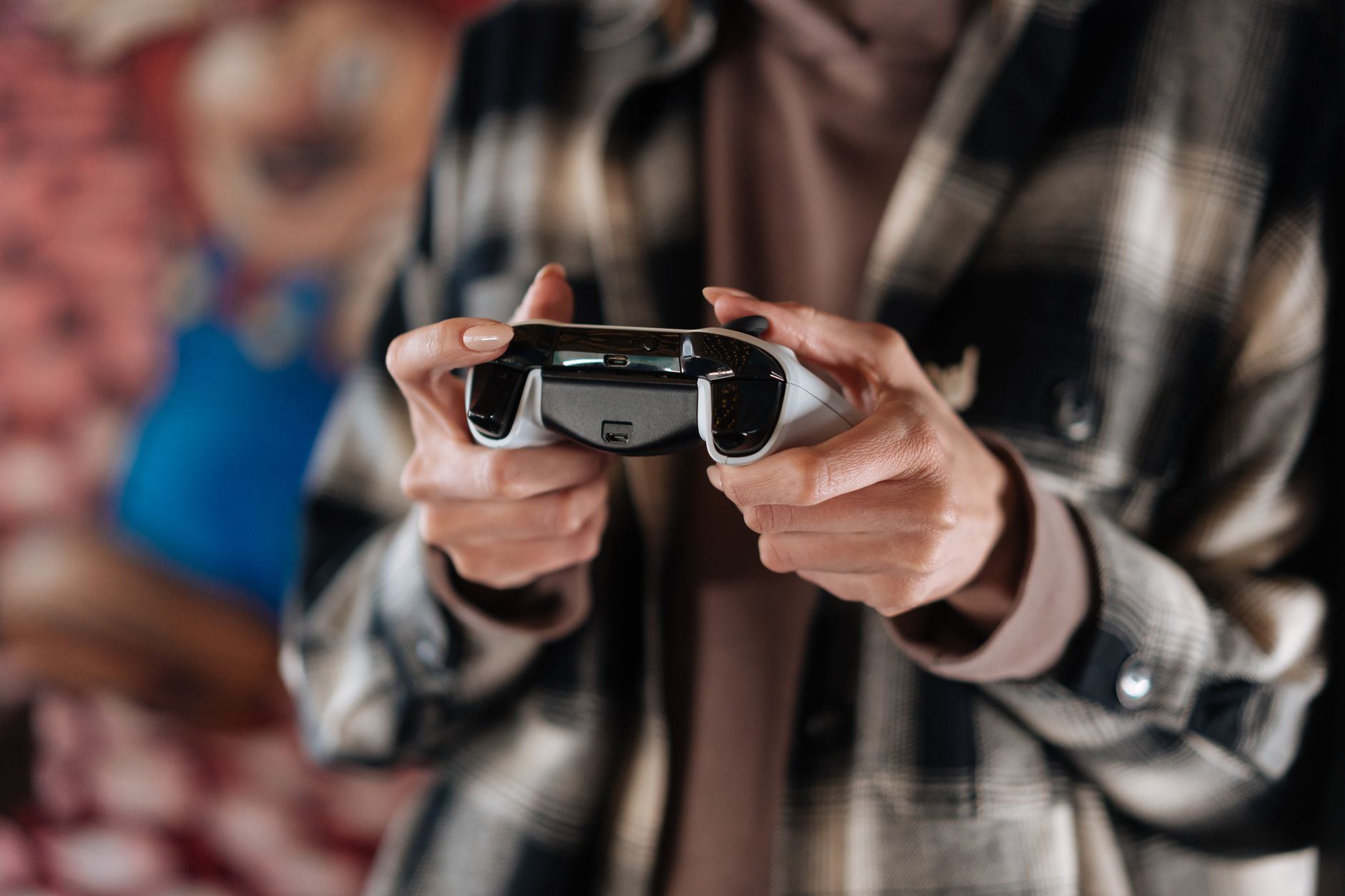 Close-up of hands holding a game controller, showcasing modern technology and gaming lifestyle.