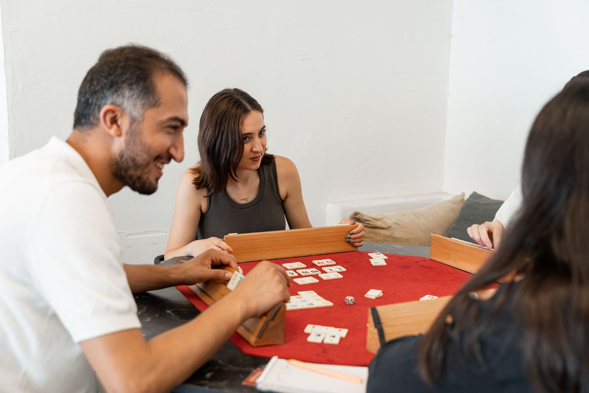 Adults enjoying a relaxing game of Rummikub together at home, focused and joyful.
