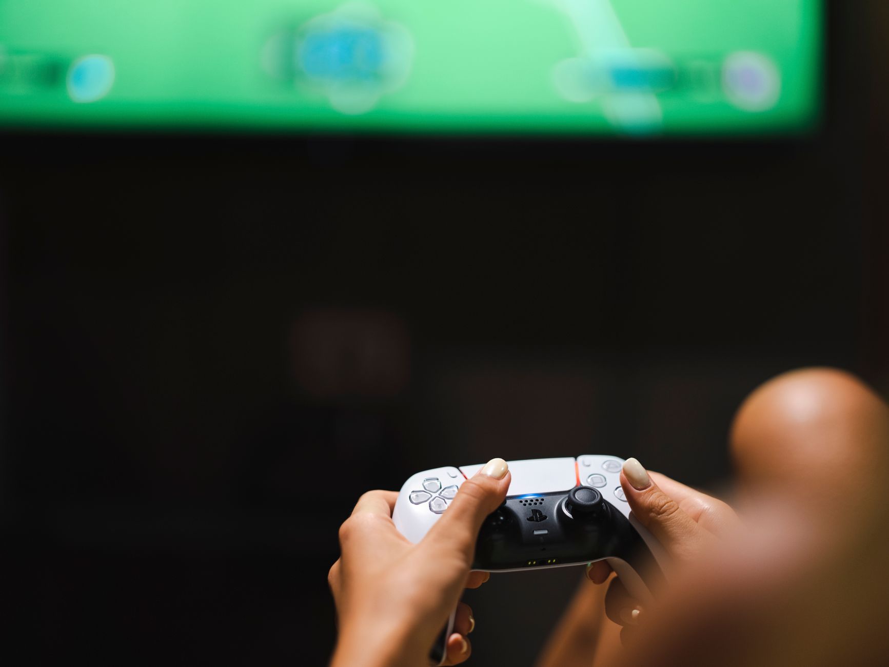 Close-up of hands holding a modern video game controller while gaming.