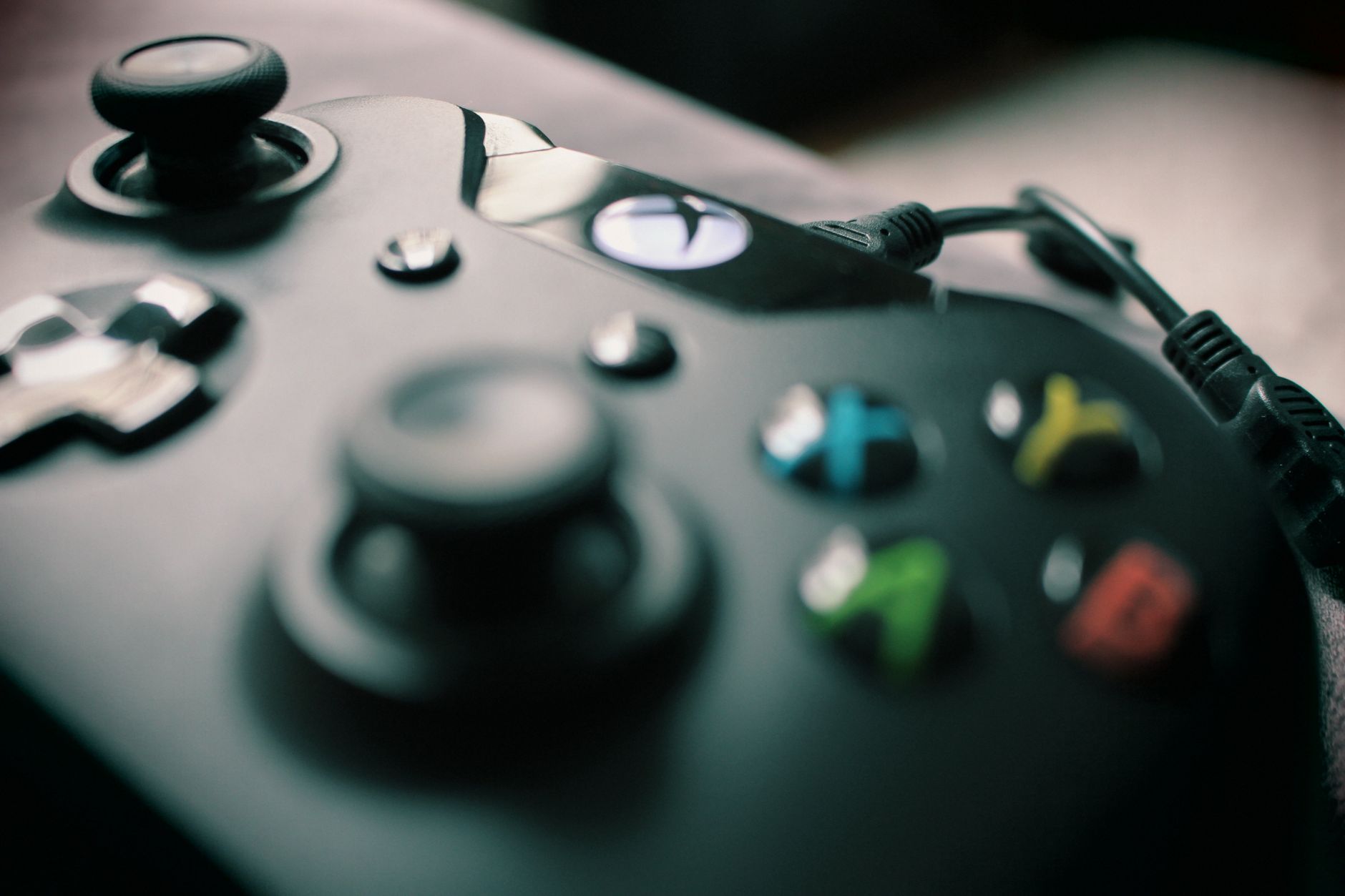 Detailed view of a black gaming controller showcasing its sleek design and colorful buttons.